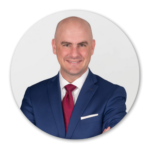 Jeremy Mazur wearing a blue suit and a red tie.